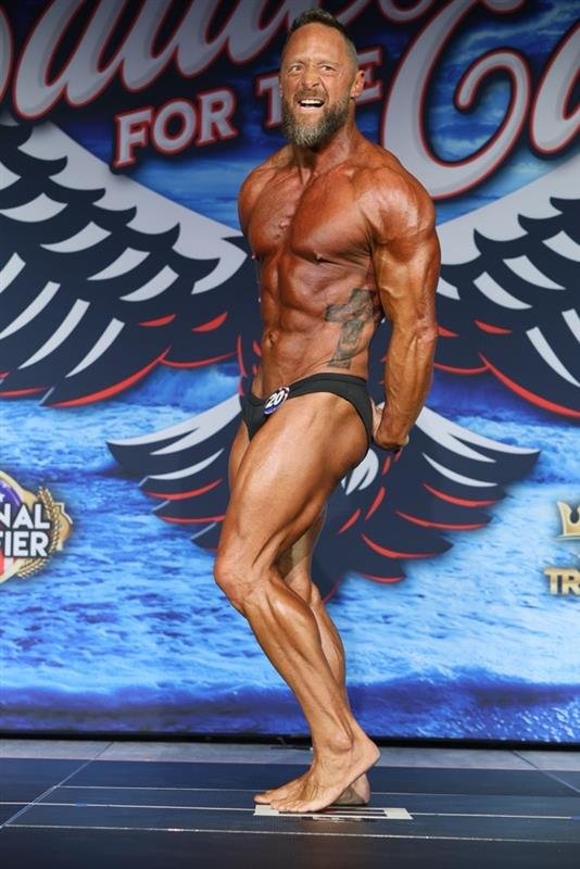 Ken Guffey posing on stage at a bodybuilding competition